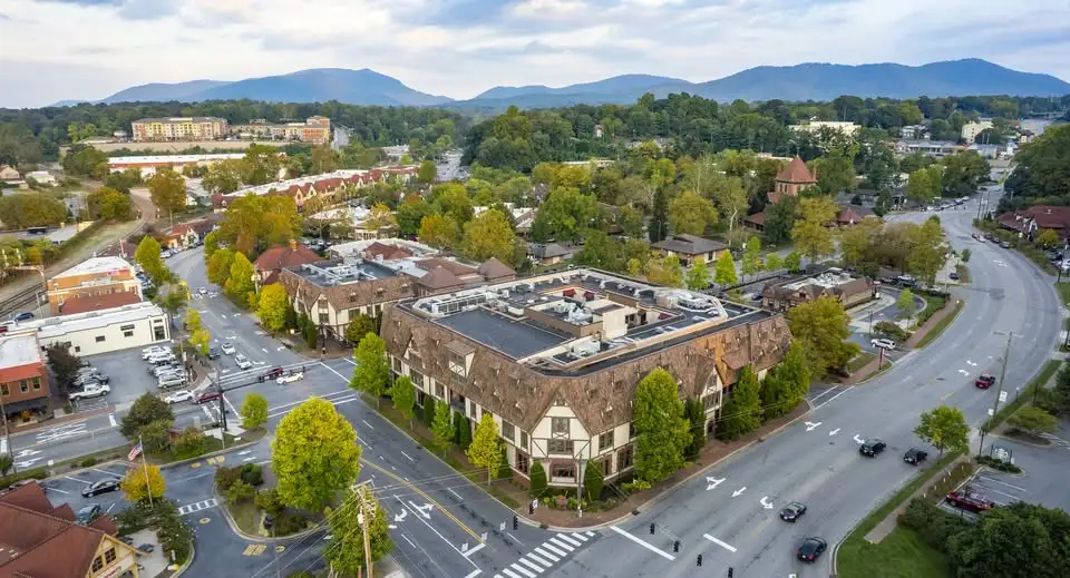 Aerial view of Biltmore Village in Asheville, North Carolina, with historic buildings and mountain backdrop.