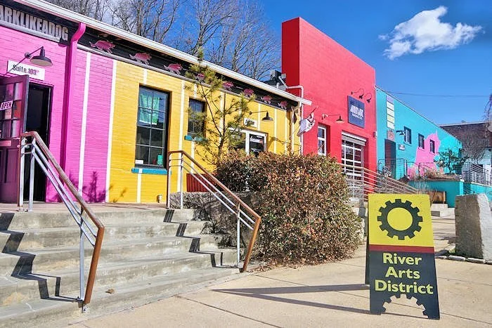 Colorful buildings in the River Arts District, Asheville, North Carolina, under a bright blue sky.