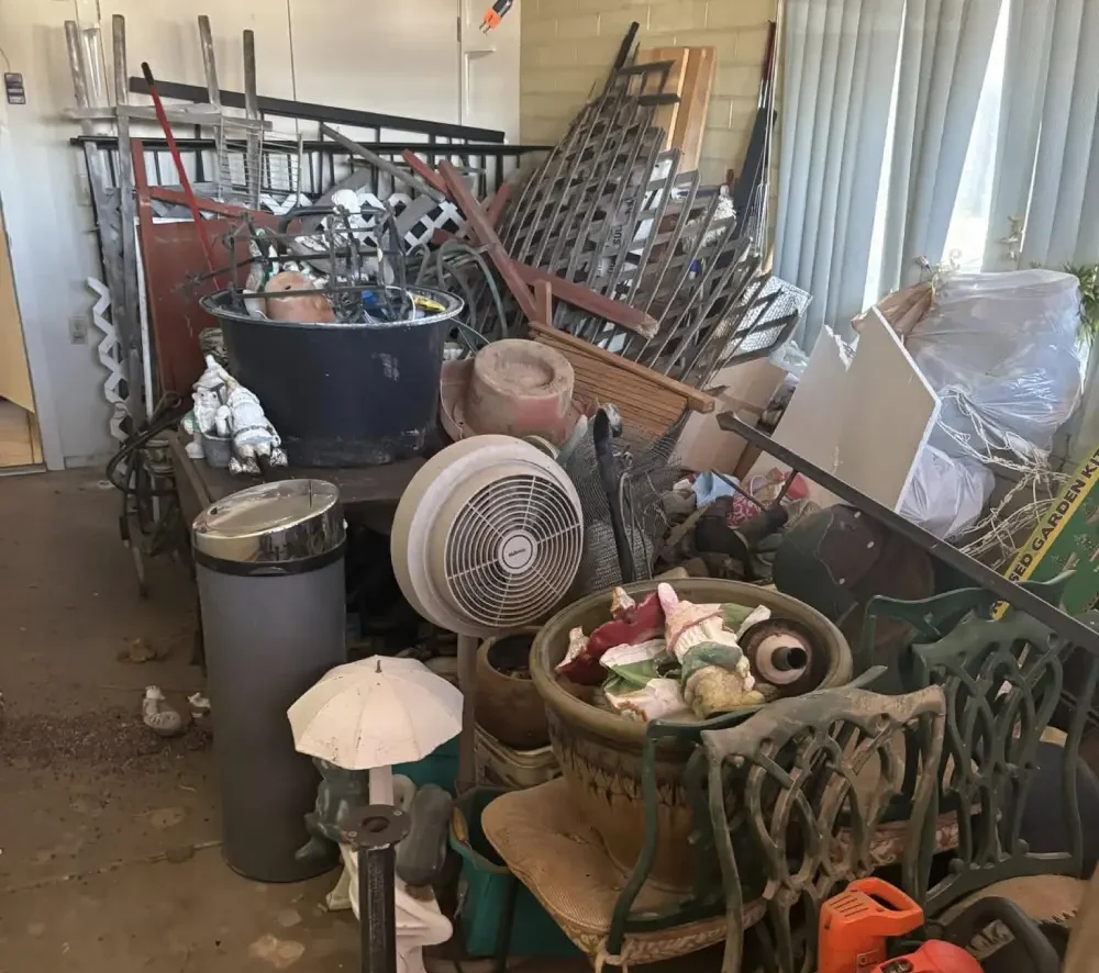 Cluttered room filled with household junk and old furniture before removal