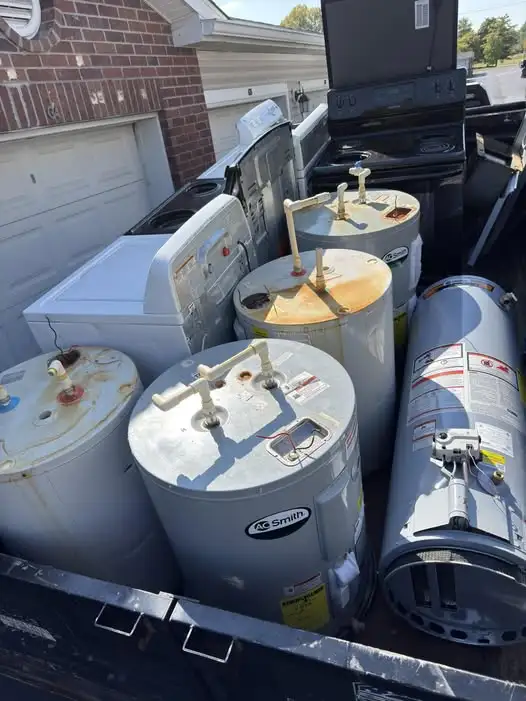 Old water heaters and home appliances loaded for junk removal