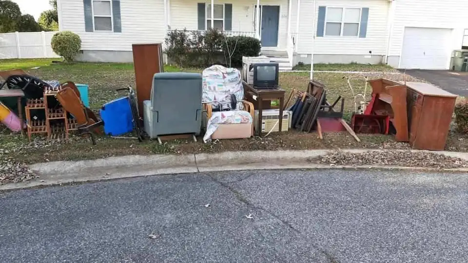 Old furniture and household items placed on curb for junk removal service