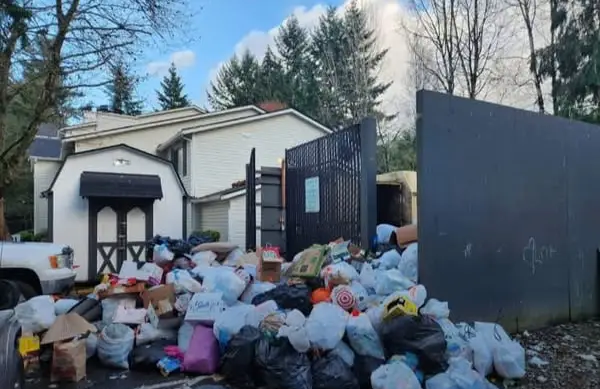 Piles of trash bags and bulk waste outside a residential property awaiting junk removal