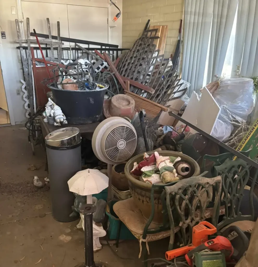 Cluttered room filled with household junk and old furniture before removal