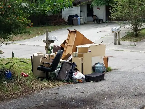 Old office furniture and trash items placed on the curb for pickup